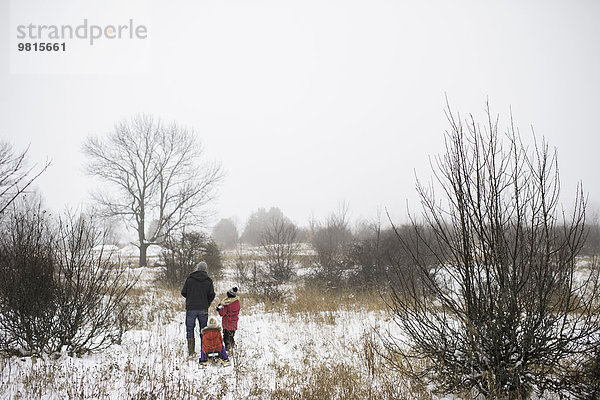 Vater und Töchter in der ländlichen Szene im Winter