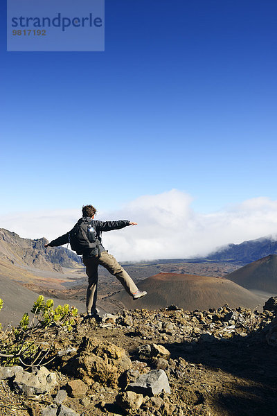 USA  Hawaii  Maui  Haleakala  Mann balanciert in Vulkanlandschaft mit Schlackenkegeln