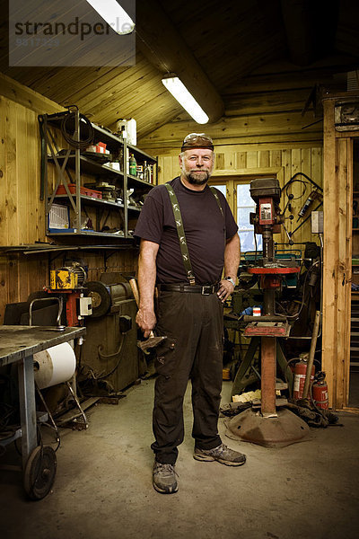 Porträt eines selbstbewussten Handwerkers in seiner Werkstatt