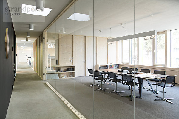Flur und moderner Konferenzraum durch Glasscheibe getrennt