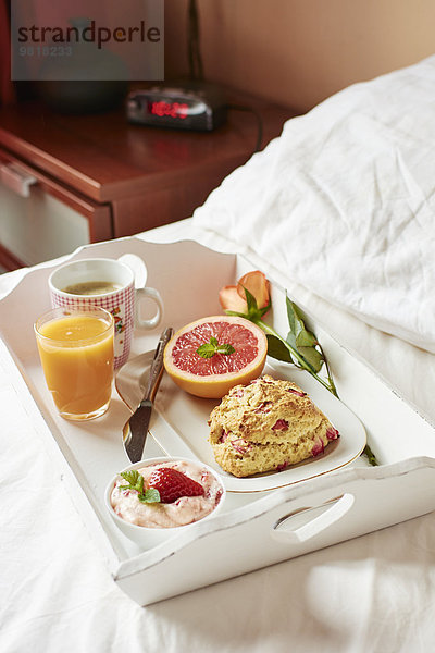 Frühstück im Bett mit hausgemachten Rhabarber-Scones  Erdbeerbutter  Grapefruit  frischem Saft und Kaffee