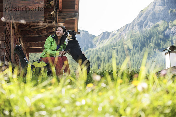 Österreich  Altenmarkt-Zauchensee  junge Frau mit Hund in der Almhütte