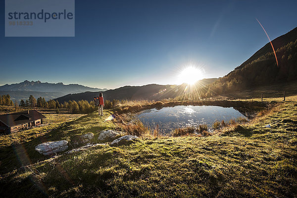 Österreich  Altenmarkt-Zauchensee  junge Frau in den Bergen bei Sonnenaufgang