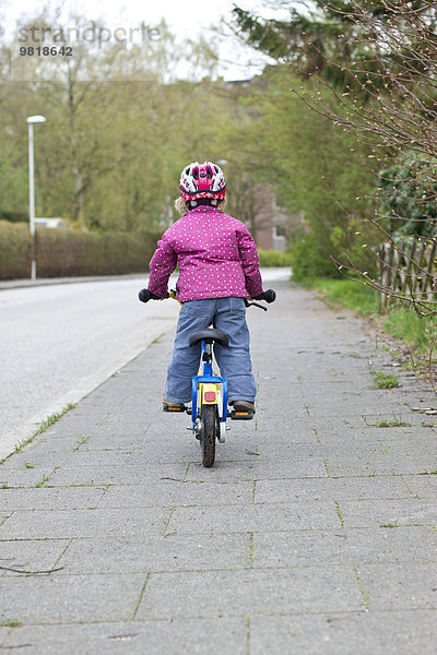 Deutschland  Kiel  Kleines Mädchen auf dem Fahrrad  Rückansicht