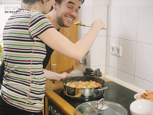 Paar probiert frisch gekochte Paella