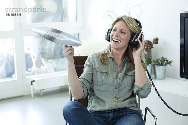 Frau hält Musik mit Kopfhörer in der Hand