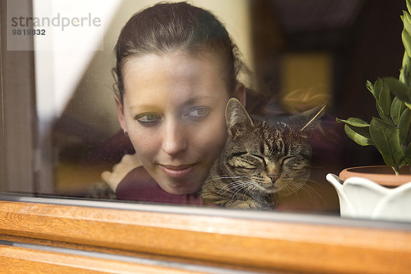 Frau und Katze am Fenster