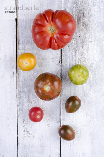 Verschiedene Tomaten auf weißem Holz