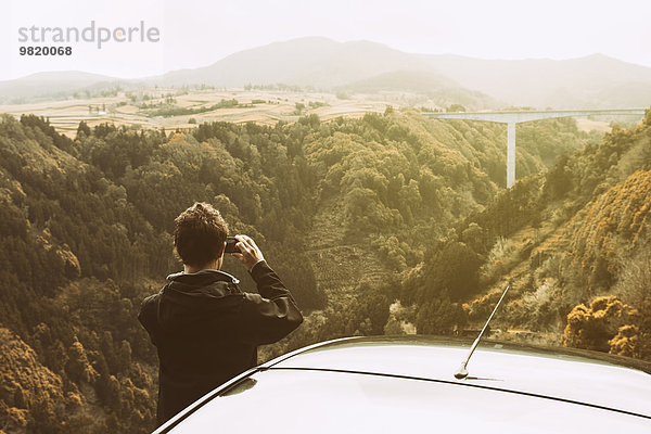 Portugal  Azoren  Mann fotografiert Landschaft mit Brücke