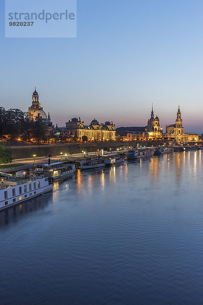 Deutschland  Dresden  Blick auf die beleuchtete Altstadt mit der Elbe im Vordergrund am Abend