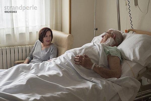 Frau  die sich um den älteren Mann kümmert  der sich nach der Operation erholt.