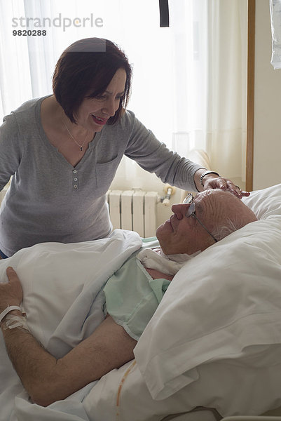 Seniorin  die ihren Mann im Krankenhaus pflegt und sich nach der Operation erholt.