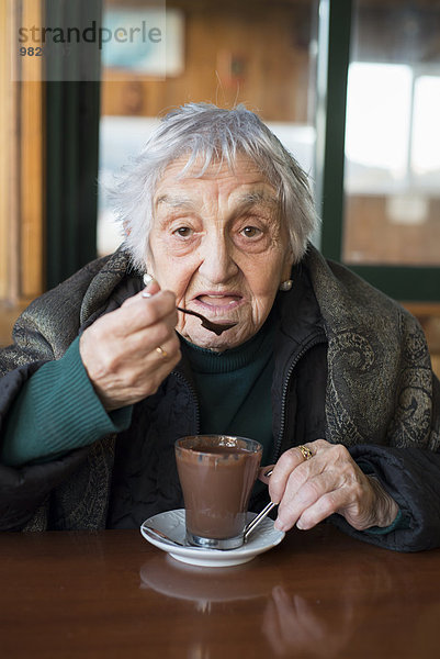 Porträt der Seniorin beim Kakao trinken am Winternachmittag