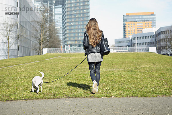 Deutschland  Düsseldorf  Junge Frau geht mit ihrem Hund spazieren