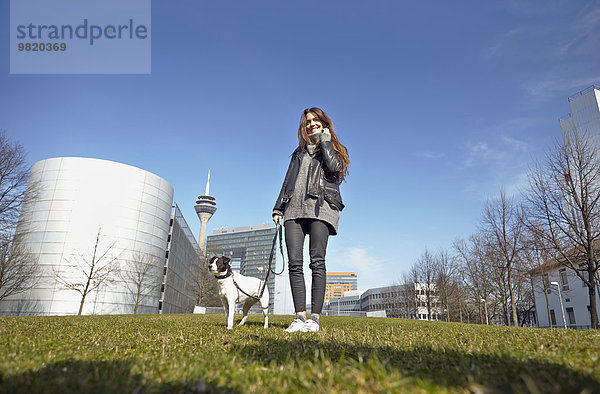 Deutschland  Düsseldorf  Junge Frau geht mit ihrem Hund spazieren