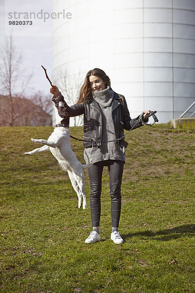 Deutschland  Düsseldorf  Junge Frau spielt mit ihrem Hund