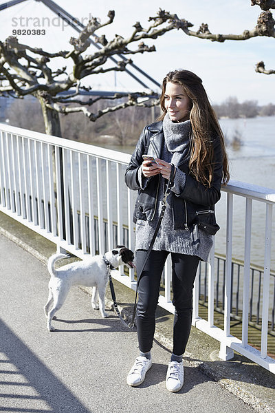 Deutschland  Düsseldorf  Junge Frau geht mit ihrem Hund spazieren