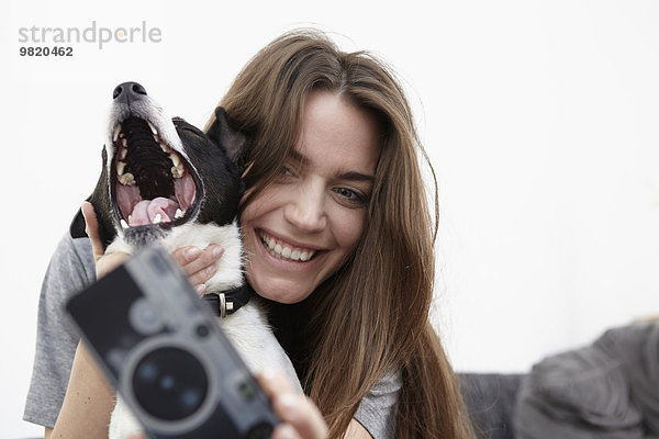 Junge Frau nimmt Selfie mit Hund