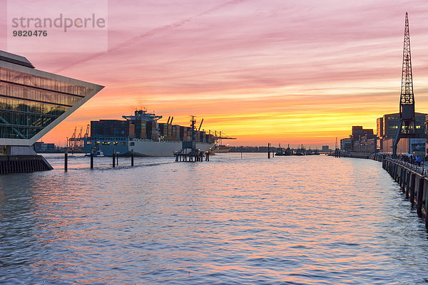 Deutschland  Hamburg  Containerschiff und Docklandgebäude bei Sonnenuntergang