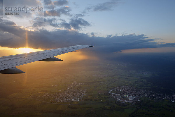Deutschland  Flugzeugflügel mit Wolken bei Sonnenuntergang