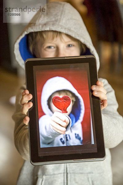 Junge zeigt digitales Tablett mit Selbstfotografie