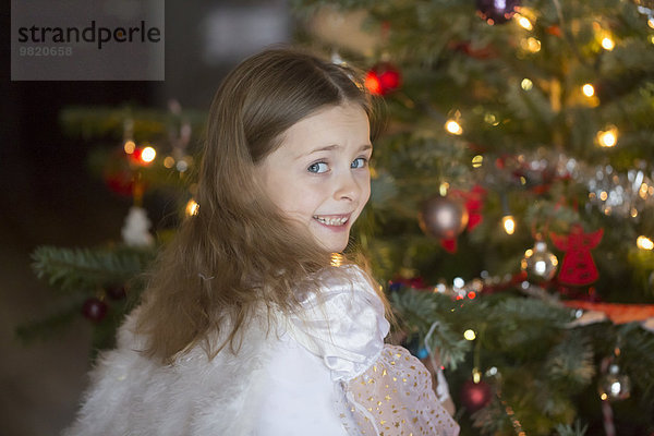 Porträt eines kleinen Mädchens mit Winkelflügeln zur Weihnachtszeit