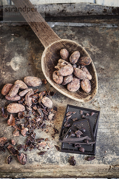 Zerkleinerte und ganze Kakaobohnen und dunkle Schokolade