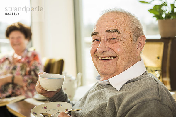 Porträt eines älteren Mannes mit einer Tasse Kaffee zu Hause