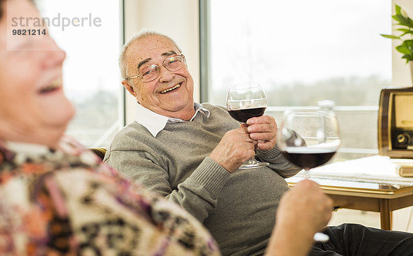 Senior Mann mit einem Glas Rotwein