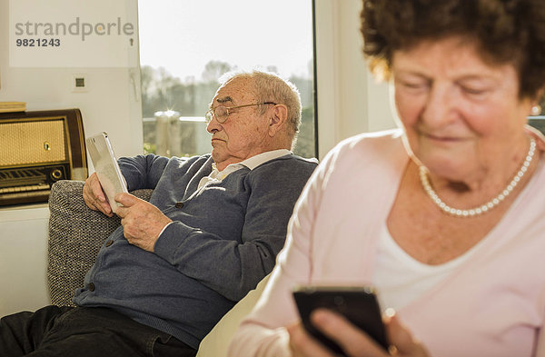 Senior Mann mit digitalem Tablett zu Hause
