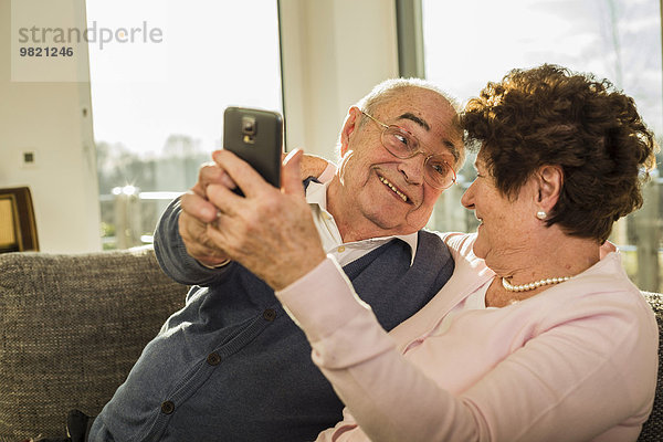 Seniorenpaar nimmt einen Selfie mit Smartphone mit nach Hause