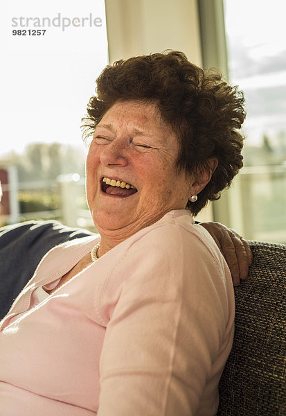 Porträt der lachenden Seniorin zu Hause
