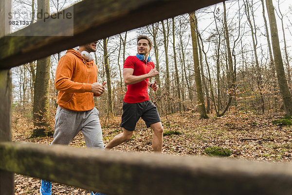 Zwei junge Männer joggen im Wald
