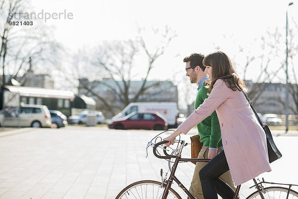 Glückliches Paar  das zusammen nach Hause geht  Frau  die Fahrrad fährt