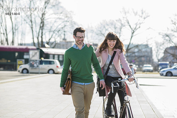 Glückliches Paar  das zusammen nach Hause geht  Frau  die Fahrrad fährt