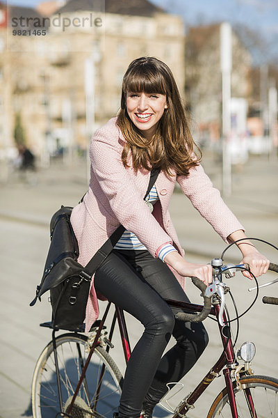 Junge Frau mit Fahrrad in der Stadt