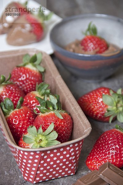 Kartonschachtel mit frischen Erdbeeren und schokolierten Erdbeeren