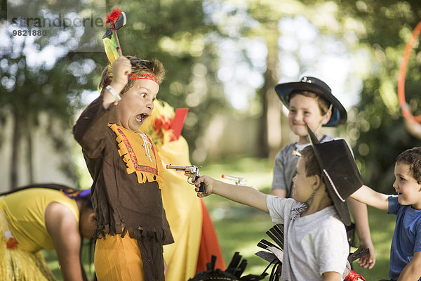 Kinder im Garten spielen Cowboys und Indianer