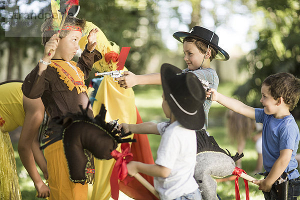 Kinder im Garten spielen Cowboys und Indianer