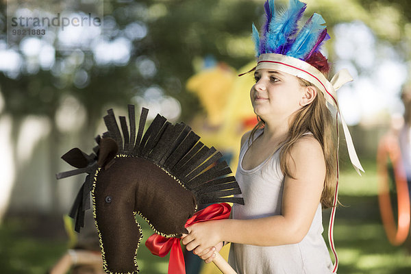 Mädchen im Garten beim Cowboy und Indianer spielen