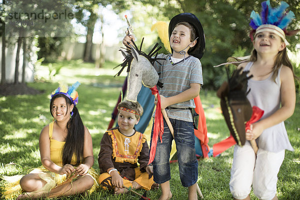 Kinder im Garten spielen Cowboys und Indianer