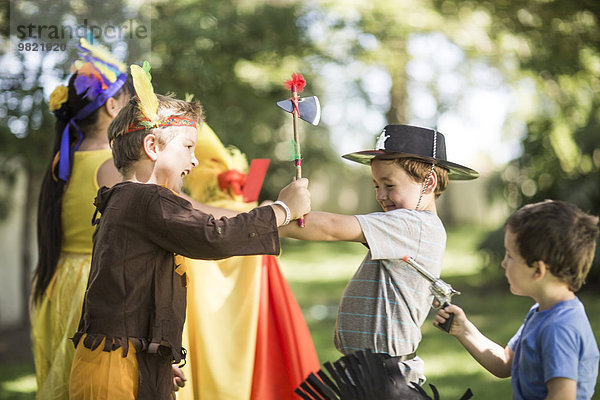 Kinder im Garten spielen Cowboys und Indianer