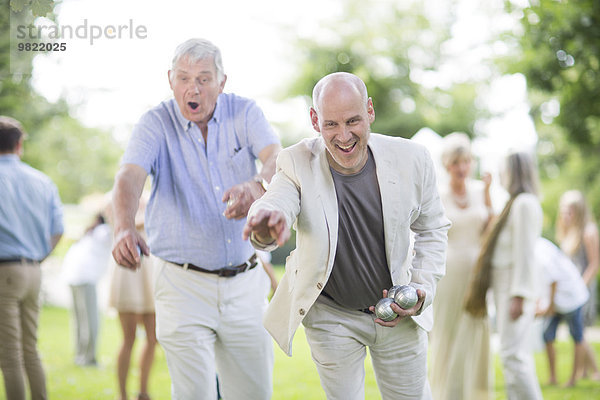 Zwei glückliche Männer beim Boulespielen im Park