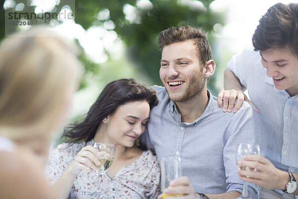 Glückliche Freunde beim Weintrinken im Freien