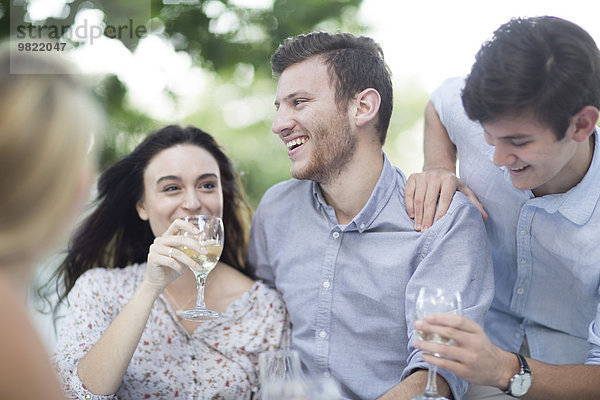 Glückliche Freunde beim Weintrinken im Freien