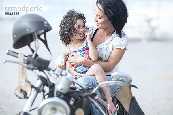 Mutter und Tochter sitzen auf dem Motorrad