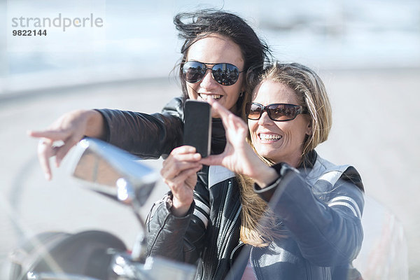 Zwei Frauen auf dem Motorrad  die Selfie nehmen.