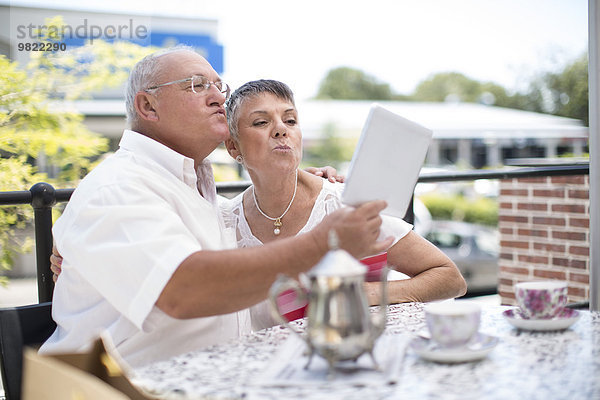 Glückliches älteres Paar  das einen Selfie mit einem Tablet-Computer nimmt.