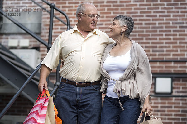 Glückliches Seniorenpaar mit Einkaufstaschen