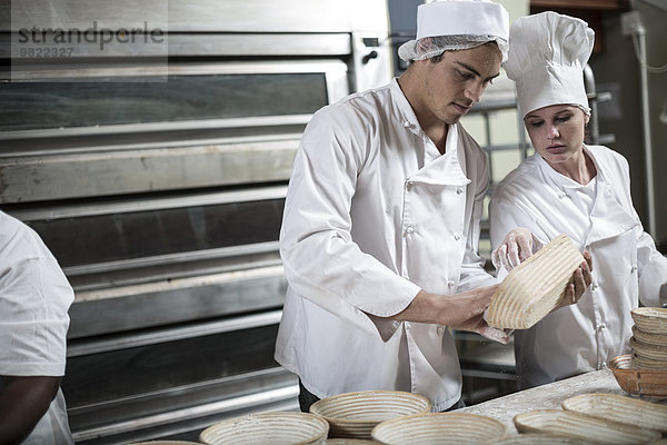 Bäcker bereitet Keramikschalen zum Brotbacken vor